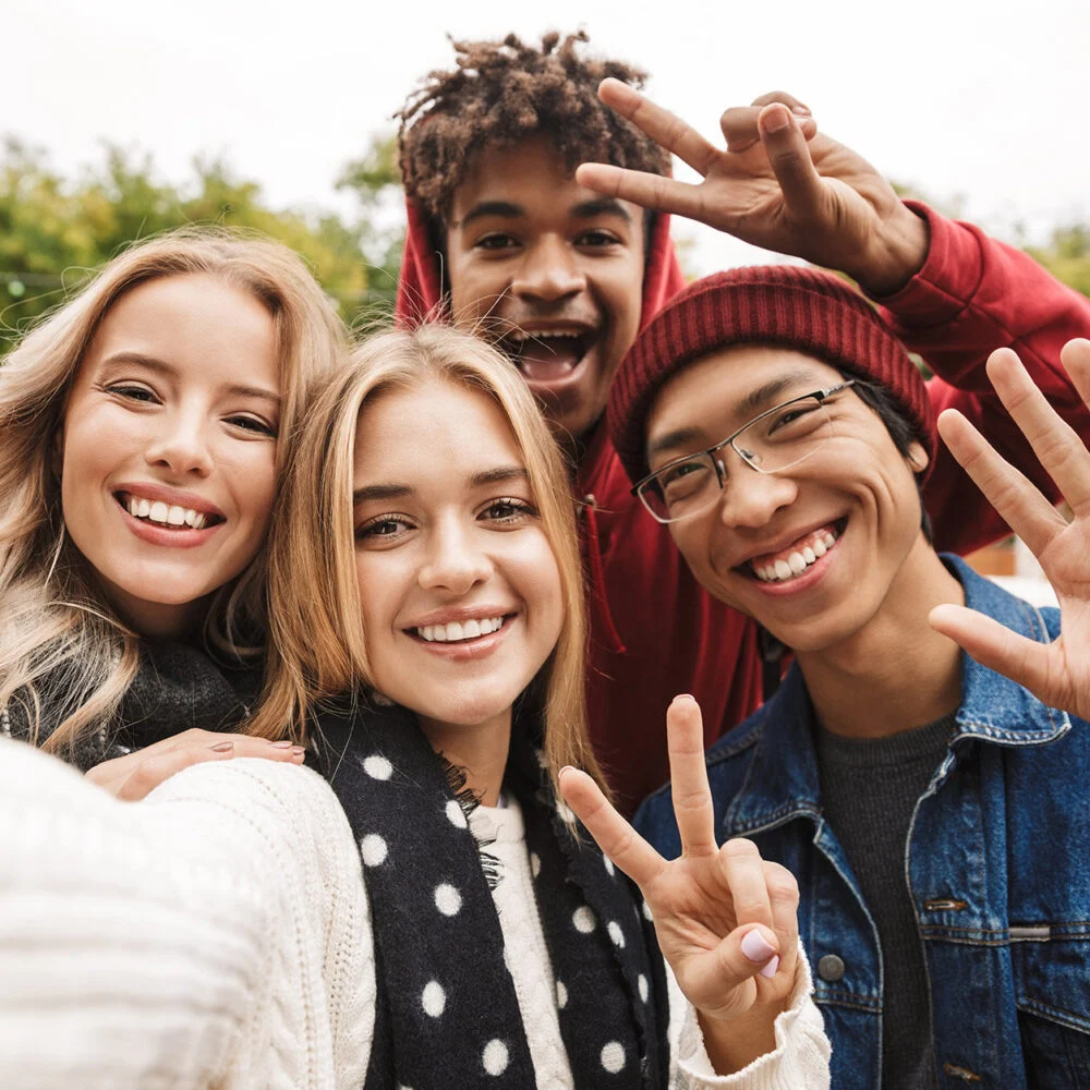 Teens laughing and taking a group selfie